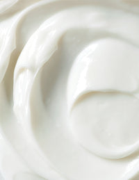 Close-up of smooth white cream with a glossy swirl texture