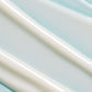 Close-up of smooth white cream swirled on a light blue background