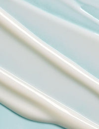 Close-up of smooth white cream swirled on a light blue background