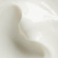 Close-up of glossy white cream with smooth, flowing texture