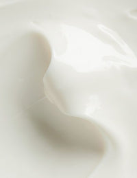 Close-up of glossy white cream with smooth, flowing texture