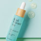 Kind Science Radiance Oil product on a pastel blue surface with floating gel bubbles