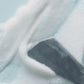 Foamy white cleanser being smoothed across a light blue surface