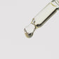 Close-up of a glass dropper releasing a clear liquid droplet against a white background